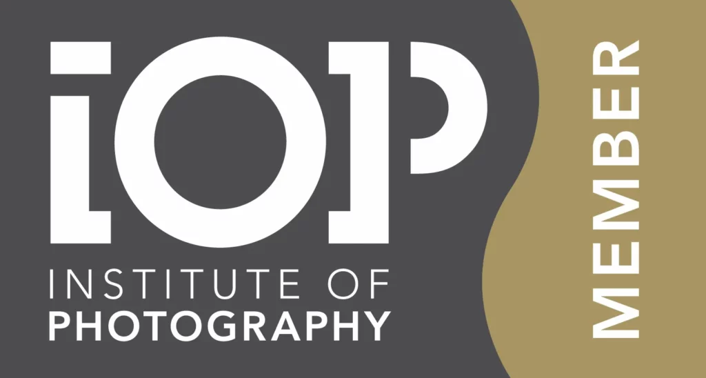 Logo for the Institute of Photography with "IOP" in large white letters and "INSTITUTE OF PHOTOGRAPHY" below. A gold wave frames the right side, with the word "MEMBER" rotated vertically. Copyright Ashley Kew Photography - All Rights Reserved